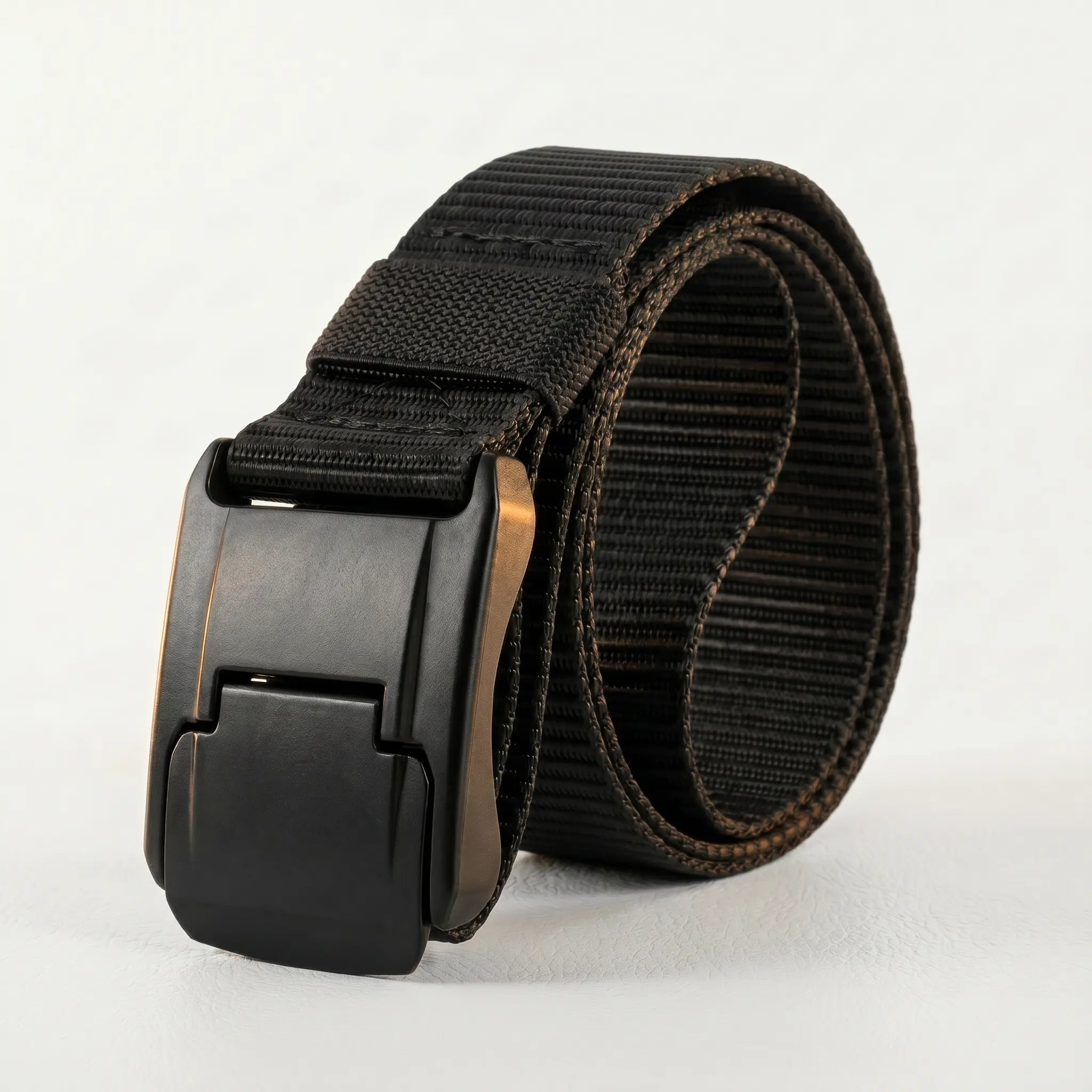 Black belt with a metallic buckle on a light gray background