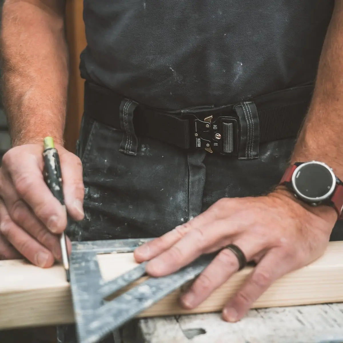 Person using a square tool on a wooden surface